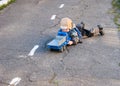 A small boy of three years old is lying on the pavement near the kindergarten with his toy truck Royalty Free Stock Photo