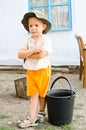 Small boy waiting with a bucket