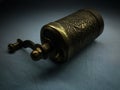 A small brass hand-held coffee grinder embossed on textiles against darkness. Traditional Turkish hand mill Royalty Free Stock Photo