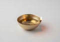 Small brass oil lamp with a lit flame on a white background Royalty Free Stock Photo