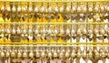 Small brass praying bells big group hanging in steel line patterns at Phra That Hariphunchai temple in Lamphun , Thailand