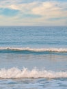 Small breaking waves with foam on the beach of the Black Sea. Beach summer landscape