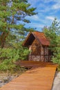 Small brick house under red tiled roof among dunes and pines in a national park public space. Russia, Kaliningrad, Zelenogradsk