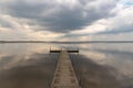 A small bridge over the lake. Reflection of clouds on the lake's surface Royalty Free Stock Photo