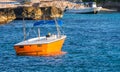 Small bright orange fishing boat, tourist boat at a tropical island