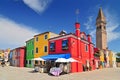 Small brightly painted houses and the Leaning Bell Tower on the island of Burano. Venice Italy