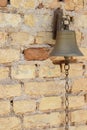 Small bronze bell fixed to a bricks wall