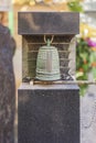 Small bronze bell hanging at the foot of Habataki Kanzeon Bosatsu statue in Tabata Togakuji temple in Tokyo