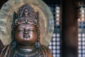 Small bronze Buddha statue with crown on his head in an old Buddhist temple of Kiyomizu Dera in Kyoto, Japan. Arts and symbols of