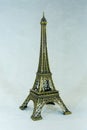 Small bronze copy of Eiffel tower figurine isolated on white background.