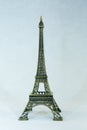 Small bronze copy of Eiffel tower figurine isolated on white background.