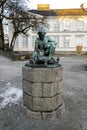 A small bronze statue of a sitting boy and ducks family in Stavanger city park