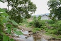 Small brook before houses in fields after summer rain