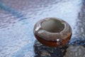 Small brown circle ceramic ashtray on glass table background, object, decor, vintage, comfortable, cigarette, copy space