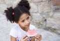 Small brown girl African American appearance eating watermelon Royalty Free Stock Photo