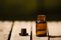 Small brown medicine bottle for magicians remedy, black cap lying next to it on wooden surface