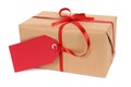 Small brown paper package or gift tied with red ribbon and gift tag isolated on white background Royalty Free Stock Photo