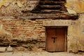 Small brown wooden door in brick wall