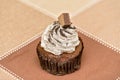 Small browny cake with whipping cream and piece of chocolate on the top
