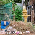 Small Buddhist sanctuary among the heaps of garbage on a city street, a garbage dump near a