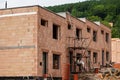 Small building construction site, wall made of orange bricks, small scaffolding near Royalty Free Stock Photo