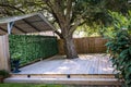 A small built out pressure treated wood deck space with a greenery covered wall to the garage Royalty Free Stock Photo