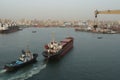 Small bulk carrier assisted by tugboat during approaching berth in port of Alexandria. Royalty Free Stock Photo