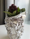 A small bunch of basil in a cup wrapped with tin foil