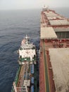 A small bunkering barge alongside to bulk carrier ship