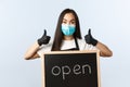 Small business, covid-19 pandemic, preventing virus and employees concept. Upbeat asian female store worker, cafe staff Royalty Free Stock Photo