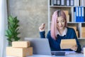 Small Business Entrepreneur SME owner cute young asian woman checking orders with laptop computer using smartphone checking orders Royalty Free Stock Photo