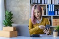 Small Business Entrepreneur SME owner cute young asian woman checking orders with laptop computer using smartphone checking orders Royalty Free Stock Photo