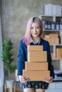 Small Business Entrepreneur SME owner cute young asian woman checking orders with laptop computer using smartphone checking orders Royalty Free Stock Photo