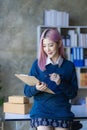 Small Business Entrepreneur SME owner cute young asian woman checking orders with laptop computer using smartphone checking orders Royalty Free Stock Photo