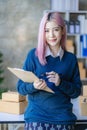 Small Business Entrepreneur SME owner cute young asian woman checking orders with laptop computer using smartphone checking orders Royalty Free Stock Photo