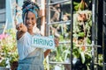 Small business, manager or black woman with a hiring sign at door entrance in floral retail store. Advertising Royalty Free Stock Photo