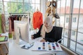 Small business of Muslim woman fashion designer Working and  using smart phone and tablet With Dresses at clothing store Royalty Free Stock Photo