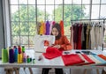 Small business of Muslim woman fashion designer Working and  using smart phone and tablet With Dresses at clothing store Royalty Free Stock Photo