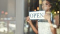 Small business, open sign and woman in cafe window for welcome, advertising and coffee shop promotion. Manager startup