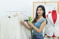 small business owner concept. young happy confident designer Asian woman with tape measure on neck use handheld bar code scanner