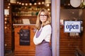Small business owner mature woman standing with arms crossed in the entrance of the cafe Royalty Free Stock Photo