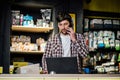 Small business owner on phone and computer in store. Sport shop worker making call with cell phone. Salesman working and talking Royalty Free Stock Photo