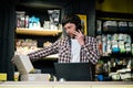 Small business owner on phone and computer in store. Sport shop worker making call with cell phone. Salesman working and talking Royalty Free Stock Photo