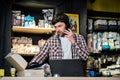 Small business owner on phone and computer in store. Sport shop worker making call with cell phone. Salesman working and talking Royalty Free Stock Photo