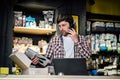 Small business owner on phone and computer in store. Sport shop worker making call with cell phone. Salesman working and talking Royalty Free Stock Photo