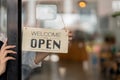 Small business owner smiling while turning the sign for the opening of the place after the quarantine due to covid-19 Royalty Free Stock Photo