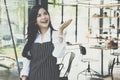 small business owner standing at coffee shop. female barista wearing apron smiling at cafe. food service, restaurant concept. Royalty Free Stock Photo