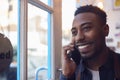 Small Business Owner Standing By Shop Door Making Call On Mobile Phone Royalty Free Stock Photo