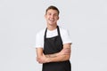 Small business owners, coffee shop and staff concept. Enthusiastic smiling, handsome waiter in black apron, laughing Royalty Free Stock Photo