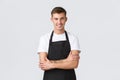 Small business owners, coffee shop and staff concept. Handsome smiling barista in black apron smiling, serving guests in Royalty Free Stock Photo